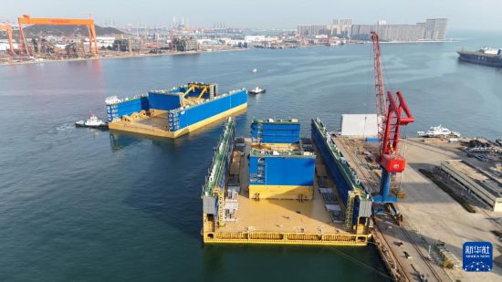 3月8日，12万吨举力浮船坞“Lucayan”号首段，从青岛西海岸新区北海造船3号码头离港（无人机照片）。     新华社发（张进刚摄）
